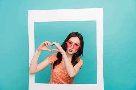 Photo of sweet shiny woman wear orange outfit eyewear standing inside paper frame showing heart...