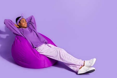 Photo of relaxed dreamy sleepy transgender enjoy beanbag nap wear headband hoodie isolated purple...