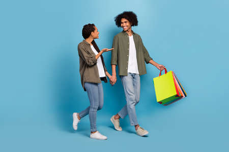 Photo of two wife husband people go center buyer packages speak wear shirt jeans isolated blue color backgroundの写真素材