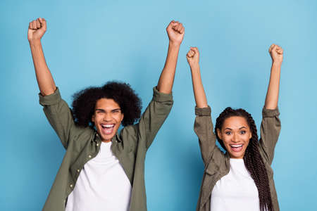Photo of crazy two colleagues guy lady fist up win lottery sale wear khaki shirt isolated blue color...