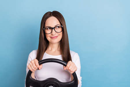 Photo of nice young brunette lady look empty space drive wear eyewear white shirt isolated on blue...