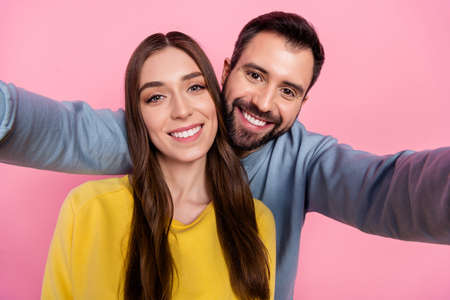 Photo of two funny positive people take selfie toothy smile good mood isolated on pink color backgroundの写真素材