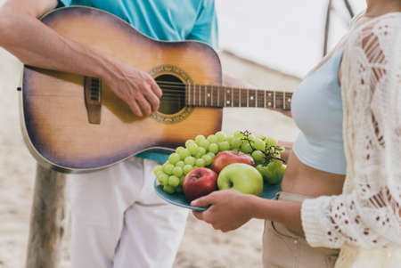 Cropped view portrait of attractive people best partners spending day good sunny weather playing guitar at beach picnic outdoorsの写真素材