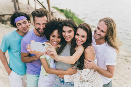 Photo of cheerful best friends take selfie together make memorable shoot video vlog chilling near seasideの写真素材