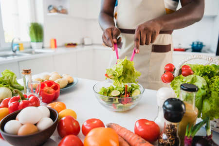 Cropped photo of young make homemade yummy veggie supper dish mix salad table in kitchen house indoorsの写真素材