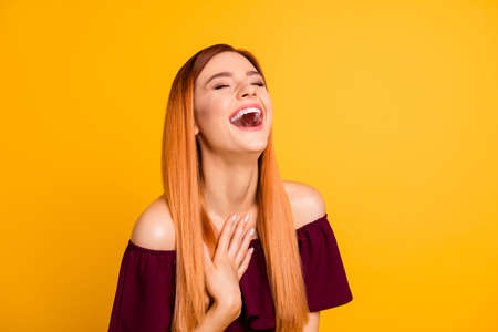 Photo of satisfied young lady closed eyes hand touch chest laughing isolated on yellow color...