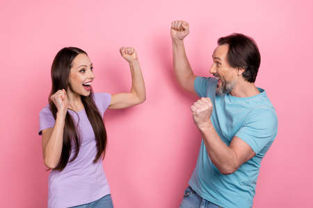 Photo of overjoyed ecstatic wife and husband celebrate their wedding anniversary isolated on pink color backgroundの写真素材
