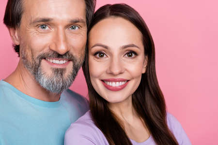 Cropped close up photo of peaceful lovely people toothy smile look camera isolated on pink color backgroundの写真素材