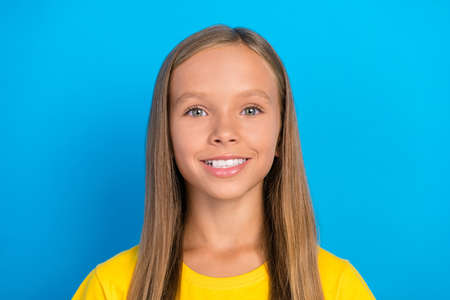 Photo of cute adorable positive little lady toothy beaming smile wear yellow t-shirt isolated blue...