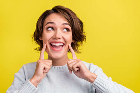 Photo of crazy candid lady finger cheek look empty space dream wear blue pullover isolated yellow...