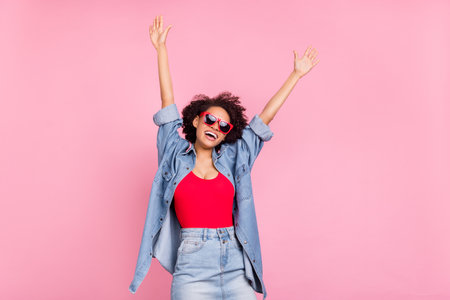 Photo of dreamy inspired lady raise hands excited rest wear sunglass jeans jacket isolated pink color backgroundの写真素材