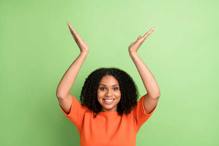 Photo of young black woman happy positive smile gesture hands advertise isolated over green color...