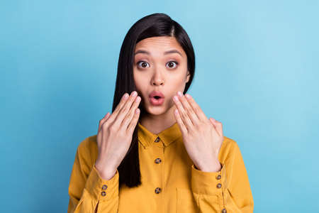 Photo of young asian girl amazed shocked surprised fake novelty news isolated over blue color...