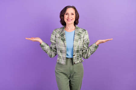 Photo of positive happy old retired pensioner woman hold hands empty space scales isolated on violet color backgroundの写真素材