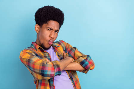 Photo of funky young brunet guy crossed arms wear checkered shirt isolated on blue color backgroundの写真素材