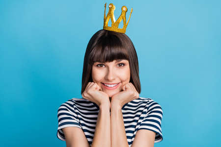 Photo of fancy brunette millennial lady wear crown striped t-shirt isolated on blue backgroundの写真素材