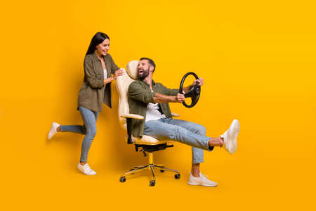 Full body profile side photo of young excited couple play game addicted isolated over yellow color backgroundの写真素材