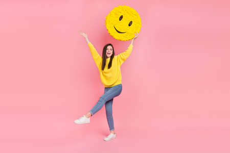 Full length photo of young cheerful woman have fun hold paper pinata promoter isolated over pink color backgroundの写真素材