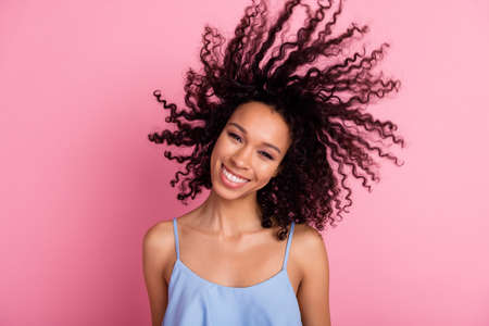Portrait of positive adorable person toothy smile flying wavy hairdo isolated on pink color backgroundの写真素材