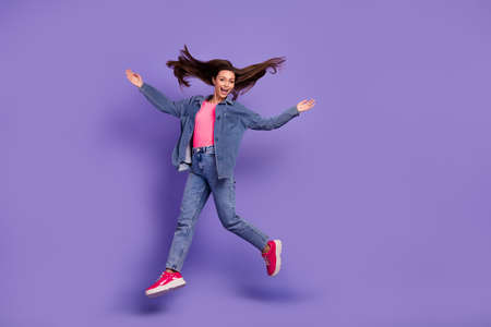 Full size portrait of overjoyed satisfied person jumping raise hands flying hair isolated on purple...