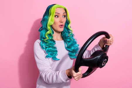 Photo of curious crazy young lady training how to drive car visit driving school isolated on pink...