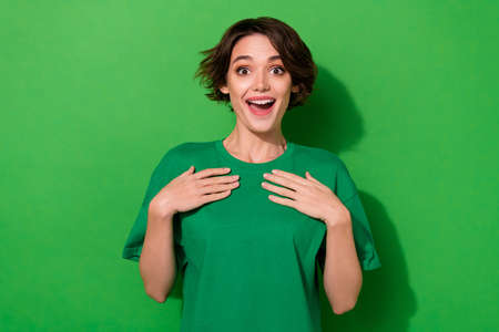 Photo of cute excited woman dressed summer t-shirt arms chest open mouth isolated green color backgroundの写真素材