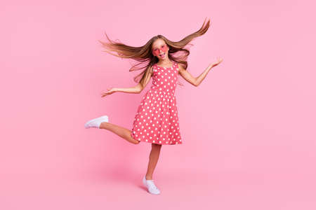 Full body portrait of overjoyed carefree girl have fun hands throw hair isolated on pink color backgroundの写真素材