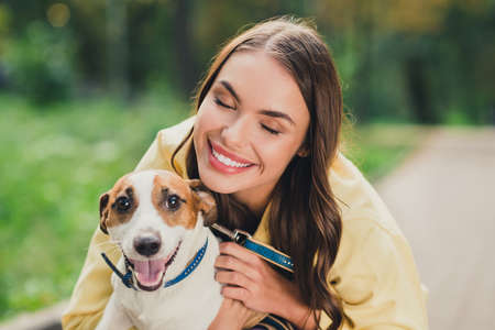 Portrait of attractive sweet cheerful girl cuddling dog having fun spending time vacation holiday...