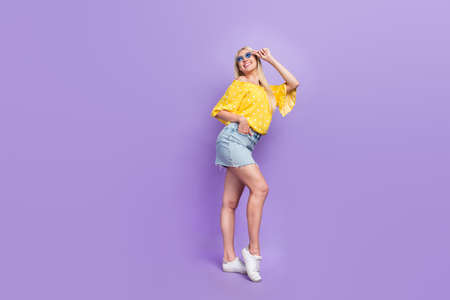 Full length photo of cute cheerful good mood girl enjoy free time summer weekend isolated on purple...