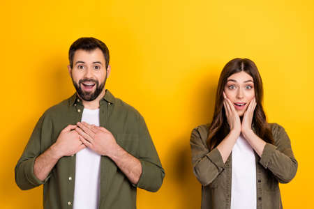 Photo of amazed beautiful couple hear good news receive gifts due engangement isolated on yellow...