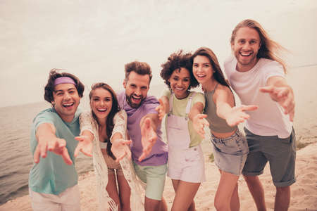 Photo of young cheerful friends happy positive smile seaside hold hands gathering party summer...