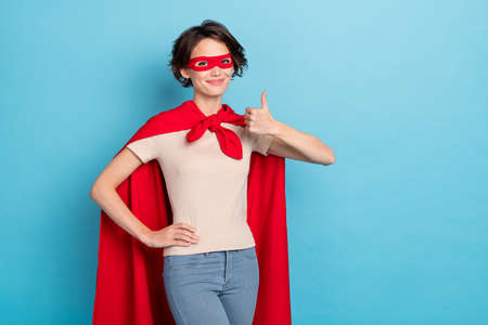 Photo of strong cool woman wear red cape showing thumb up empty space isolated blue color backgroundの写真素材