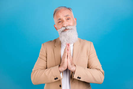 Portrait of handsome classy grey-haired man asking you favor hope luck isolated over bright blue...