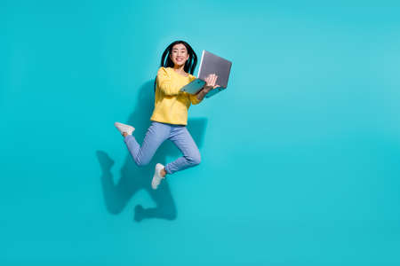 Full length photo of sweet funky woman wear yellow pullover reading gadget jumping empty space...