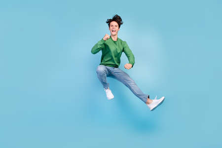 Full length body size photo guy jumping high gesturing like winner isolated pastel blue color...