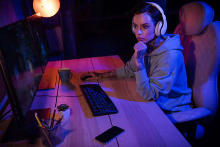 Profile portrait of professional gamer girl sitting chair arm touch chin look two displays evening...