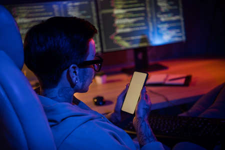 Photo of serious busy it specialist dressed sweatshirt piercing glasses reading tasks modern gadget...