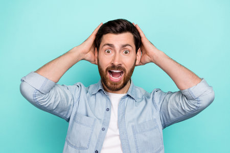 Photo of panic guy touch head incredible discounts scream wear denim stylish clothes isolated cyan...
