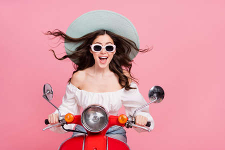 Portrait of surprised positive person drive vehicle moped have fun isolated on pink color backgroundの写真素材