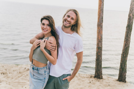Photo of pretty sweet husband wife walking smiling embracing enjoying summer time outdoors ocean...