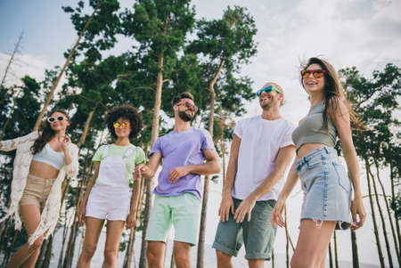 Photo of five cheerful carefree friends have fun hanging out forest festival party outdoorsの写真素材