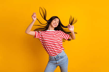 Photo of pretty positive lady closed eyes flying black hair dancing wear red white t-shirt isolated...