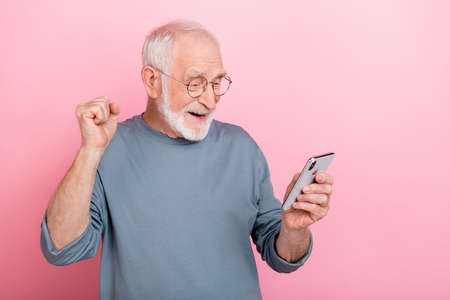 Photo of hooray elder grey hairdo man look telephone wear eyewear blue shirt isolated on pink color backgroundの写真素材