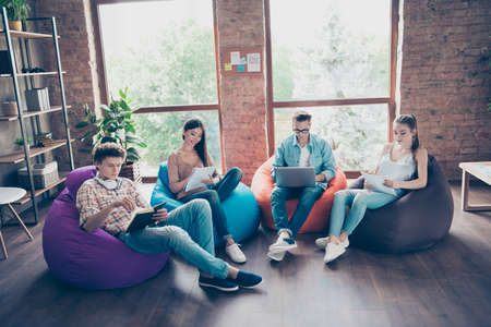 Photo of busy serious groupmates sitting dormitory preparing tests learning subjects indoors workstation workshopの写真素材