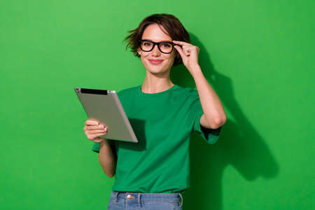 Photo of intelligent pretty young lady dressed casual t-shirt eyewear typing modern gadget isolated...