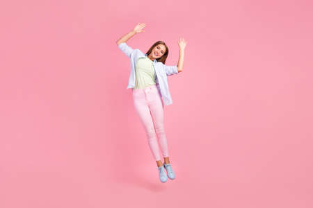 Full body photo of gorgeous glad person jumping raise opened hands palms isolated on pink color...