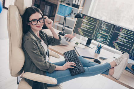 Profile side view portrait of attractive cheerful girl tech support service expert providing solution at workplace workstation indoorsの写真素材