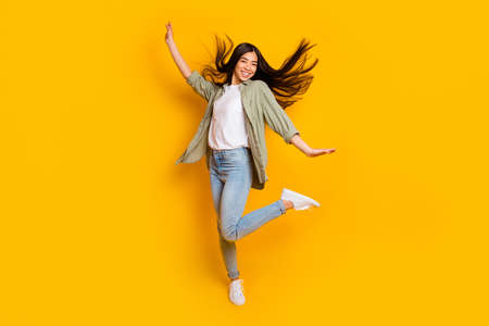 Full body portrait of positive overjoyed girl enjoy dancing clubbing isolated on yellow color backgroundの写真素材