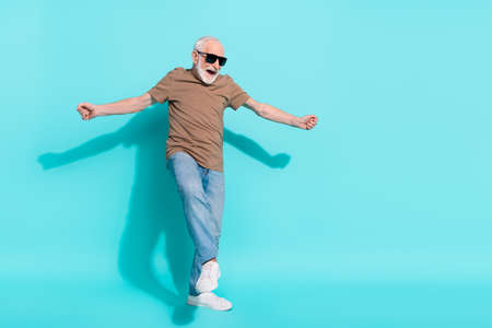 Full length body size view of attractive cheerful grey-haired man dancing having fun isolated over...
