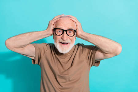 Portrait of attractive cheerful wondered grey-haired man great news reaction isolated over bright blue color backgroundの写真素材